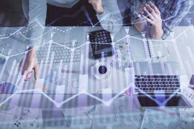 Kadın ve erkeğin birlikte çalışması ve finansal grafik hologramı çizimi. Pazar analizi konsepti. Bilgisayar arkaplanı. Üst Görünüm.