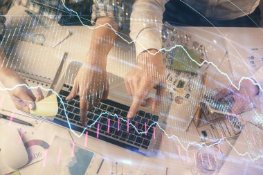 Kadın ve erkeğin birlikte çalıştığı çoklu pozlama ve grafik hologramı çizimi. Finansal analiz konsepti. Bilgisayar arkaplanı. Üst Görünüm.