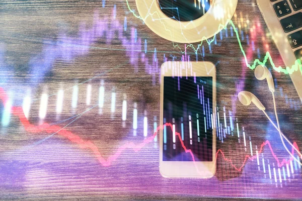 Doble exposición del holograma gráfico de divisas sobre el escritorio con el teléfono. Vista superior. Concepto de plataforma de comercio móvil. —  Fotos de Stock
