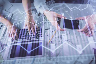 Kadın ve erkeğin birlikte çalıştığı çoklu pozlama ve grafik hologramı çizimi. Finansal analiz konsepti. Bilgisayar arkaplanı. Üst Görünüm.