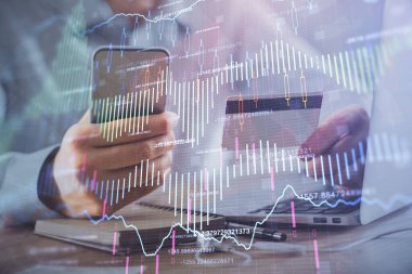 Ellerinde kredi kartı ve forex çizimi olan bir adamın çift pozu. İnternet E-ticaret kavramında hisse senedi ve dijital fintech.