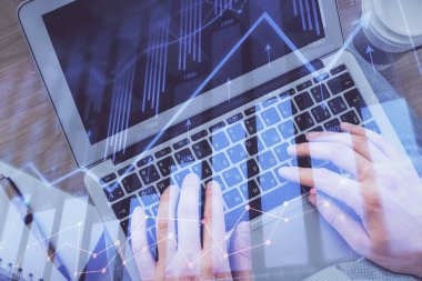 Erkeklerin ellerinin bilgisayar klavyesini ve ön grafik hologram çizimlerini yazarken çifte pozlama. Üst Manzara. Finans piyasası kavramı.