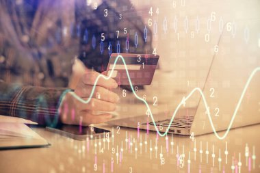 İnternetten alışveriş yapan kadının elinde kredi kartı ve mali grafik çizimi var. Borsa E-ticaret kavramı.