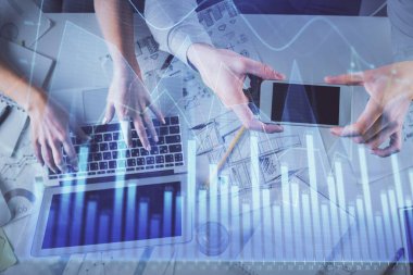 Kadın ve erkeğin birlikte çalıştığı çoklu pozlama ve grafik hologramı çizimi. Finansal analiz konsepti. Bilgisayar arkaplanı. Üst Görünüm.