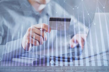 Ellerinde kredi kartı ve forex çizimi olan bir adamın çift pozu. İnternet E-ticaret kavramında hisse senedi ve dijital fintech.