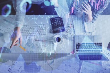 Kadın ve erkeğin birlikte çalışması ve finansal grafik hologramı çizimi. Pazar analizi konsepti. Bilgisayar arkaplanı. Üst Görünüm.