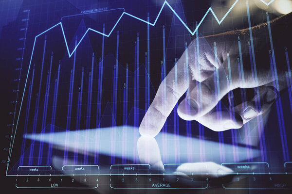 Double exposure of mans hands holding and using a digital device and forex graph drawing. Financial market concept.