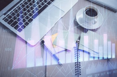 Borsa grafiği ve masa arkasındaki en üst görünüm bilgisayarı. Çifte maruziyet. Finansal eğitim kavramı.