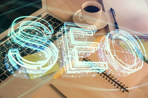 Double exposure of SEO writing and desktop with coffee and items on table background. Concept of search optimization. — Stock Photo, Image