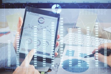 Bir adamın el ele tutuşup, telefon ve finansal çizim kullanırken birden fazla pozlama. Pazar analizi kavramı.