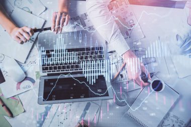 Kadın ve erkeğin birlikte çalışması ve finansal grafik hologramı. İş konsepti. Bilgisayar arkaplanı.