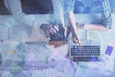 Kadın ve erkeğin birlikte çalışması ve finansal grafik hologramı çizimi. Pazar analizi konsepti. Bilgisayar arkaplanı. Üst Görünüm.