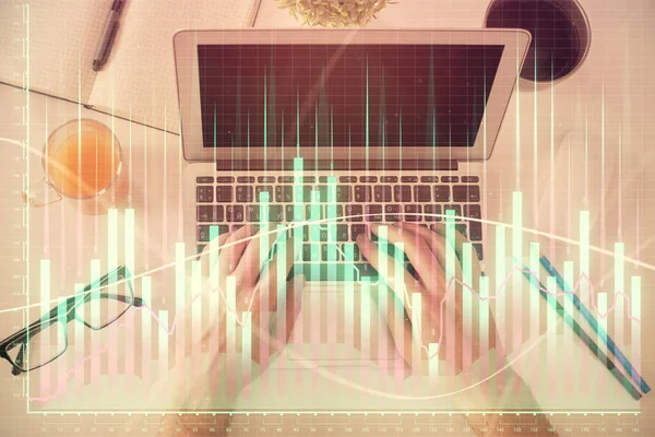 노트북 키보드와 전산 차트 홀로그램 그림을 통해 타자를 치는 사람들의 손 이 두 번 노출되었다. 위에서 본 모습. 금융 시장의 개념. — 스톡 사진