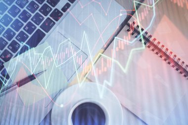 Borsa grafiği ve masa arkasındaki en üst görünüm bilgisayarı. Çifte maruziyet. Finansal eğitim kavramı.