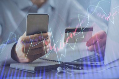 Ellerinde kredi kartı ve forex çizimi olan bir adamın çift pozu. İnternet E-ticaret kavramında hisse senedi ve dijital fintech.