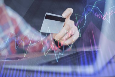 Ellerinde kredi kartı ve forex çizimi olan bir adamın çift pozu. İnternet E-ticaret kavramında hisse senedi ve dijital fintech.