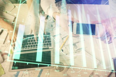 Kadın ve erkeğin birlikte çalıştığı çoklu pozlama ve grafik hologramı çizimi. Finansal analiz konsepti. Bilgisayar arkaplanı. Üst Görünüm.