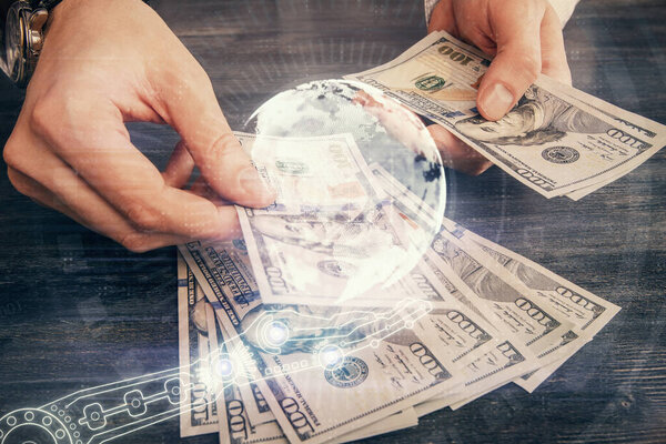 Двойная экспозиция карты мира рисования голограммы и нас долларовые купюры и руки человека.