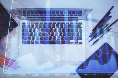Forx grafiğinin bilgisayar ile masa arkaplanının üzerine çizimi. Finansal araştırma ve analiz kavramı. Üst görünüm.
