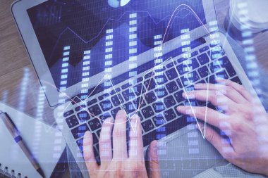 Erkeklerin ellerinin bilgisayar klavyesini ve ön grafik hologram çizimlerini yazarken çifte pozlama. Üst Manzara. Finans piyasası kavramı.