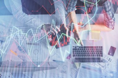 Kadın ve erkeğin birlikte çalışması ve finansal grafik hologramı çizimi. Pazar analizi konsepti. Bilgisayar arkaplanı. Üst Görünüm.