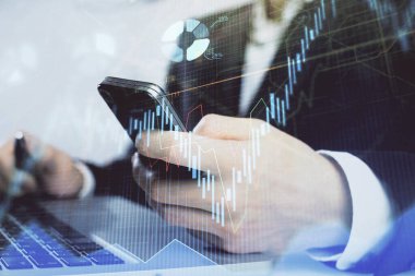 Dijital telefon ve forx grafik çizimi kullanarak adamın elini tutarken birden fazla pozlama. Finansal piyasa kavramı.