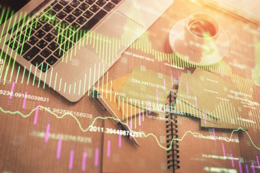 Borsa grafiği ve masa arkasındaki en üst görünüm bilgisayarı. Çifte maruziyet. Finansal eğitim kavramı.