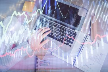 İnsan elinin bilgisayar klavyesinde ve forx grafik hologramının üzerinde yazarken çifte pozlama. Üst Manzara. Finans piyasası kavramı.