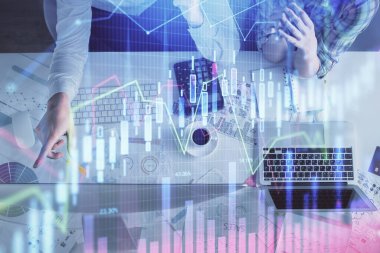 Kadın ve erkeğin birlikte çalışması ve finansal grafik hologramı çizimi. Pazar analizi konsepti. Bilgisayar arkaplanı. Üst Görünüm.