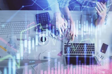 Kadın ve erkeğin birlikte çalışması ve finansal grafik hologramı çizimi. Pazar analizi konsepti. Bilgisayar arkaplanı. Üst Görünüm.
