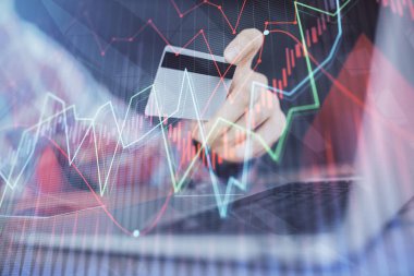 Ellerinde kredi kartı ve forex çizimi olan bir adamın çift pozu. İnternet E-ticaret kavramında hisse senedi ve dijital fintech.