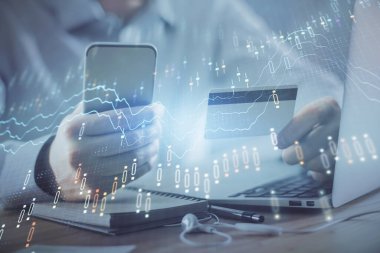 Ellerinde kredi kartı ve forex çizimi olan bir adamın çift pozu. İnternet E-ticaret kavramında hisse senedi ve dijital fintech.