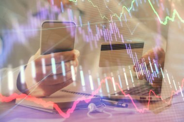 Ellerinde kredi kartı ve forex çizimi olan bir adamın çift pozu. İnternet E-ticaret kavramında hisse senedi ve dijital fintech.