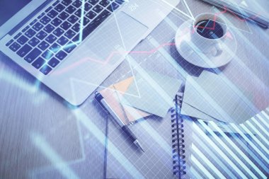 Borsa grafiği ve masa arkasındaki en üst görünüm bilgisayarı. Çifte maruziyet. Finansal eğitim kavramı.