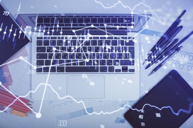 Forx grafiğinin bilgisayar ile masa arkaplanının üzerine çizimi. Finansal araştırma ve analiz kavramı. Üst görünüm.