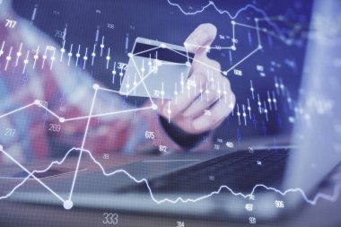 Ellerinde kredi kartı ve forex çizimi olan bir adamın çift pozu. İnternet E-ticaret kavramında hisse senedi ve dijital fintech.