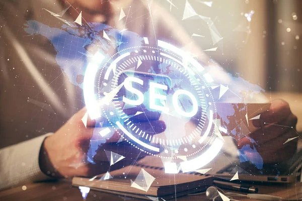 Erkeklerin el ele tutuşup dijital bir cihaz ve seo çizimi kullanırken birden fazla pozlama. arama optimizasyonu kavramı.