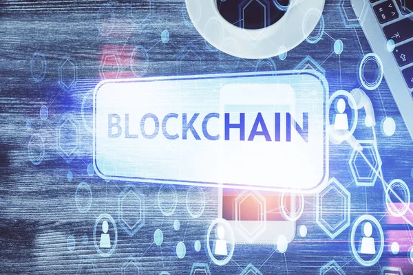 Telefonlu masanın üzerinde iki kat daha fazla engelleme temalı hologram görüntüsü var. Üst Manzara. Kripto teknolojisi kavramı.