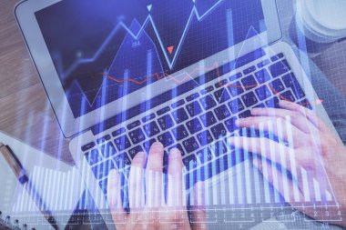 Erkeklerin ellerinin bilgisayar klavyesini ve ön grafik hologram çizimlerini yazarken çifte pozlama. Üst Manzara. Finans piyasası kavramı.