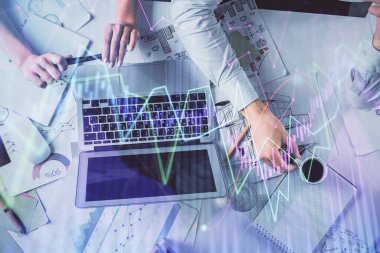 Kadın ve erkeğin birlikte çalışması ve finansal grafik hologramı. İş konsepti. Bilgisayar arkaplanı.