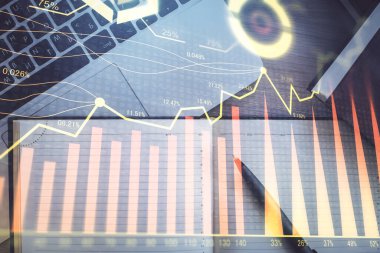 Borsa grafiği ve masa arkasındaki en üst görünüm bilgisayarı. Çoklu maruz kalma. Finansal eğitim kavramı.