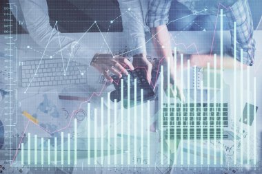 Kadın ve erkeğin birlikte çalışması ve finansal grafik hologramı çizimi. Pazar analizi konsepti. Bilgisayar arkaplanı. Üst Görünüm.