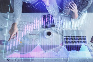 Kadın ve erkeğin birlikte çalışması ve finansal grafik hologramı çizimi. Pazar analizi konsepti. Bilgisayar arkaplanı. Üst Görünüm.