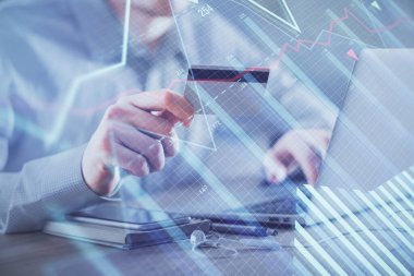 Ellerinde kredi kartı ve forex çizimi olan bir adamın çift pozu. İnternet E-ticaret kavramında hisse senedi ve dijital fintech.