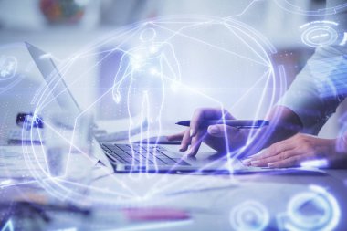 Bilgisayarda yazı yazan kadın elleri ve genel temalı hologram çizimleri. Eğitim kavramı.