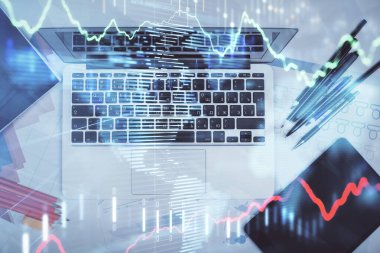 Forx grafiğinin bilgisayar ile masa arkaplanının üzerine çizimi. Finansal araştırma ve analiz kavramı. Üst görünüm.