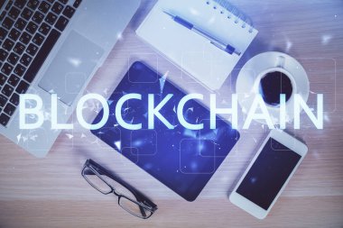 Telefonlu masanın üzerinde iki kat daha fazla engelleme temalı hologram görüntüsü var. Üst Manzara. Kripto teknolojisi kavramı.