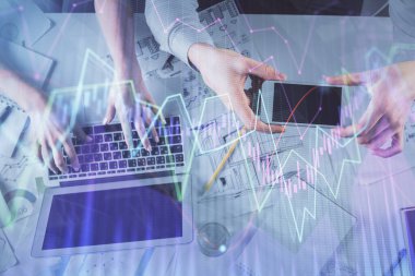 Kadın ve erkeğin birlikte çalıştığı çoklu pozlama ve grafik hologramı çizimi. Finansal analiz konsepti. Bilgisayar arkaplanı. Üst Görünüm.