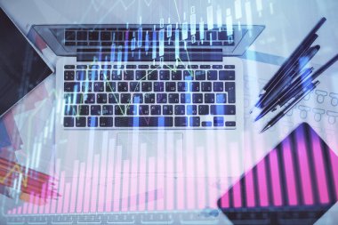 Forx grafiğinin bilgisayar ile masa arkaplanının üzerine çizimi. Finansal araştırma ve analiz kavramı. Üst görünüm.