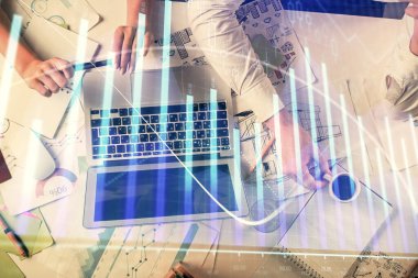 Kadın ve erkeğin birlikte çalışması ve finansal grafik hologramı. İş konsepti. Bilgisayar arkaplanı.